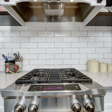 Kitchen range and custom hood canopy above.