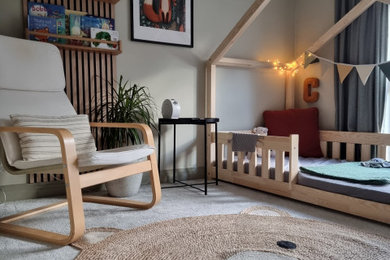 Photo of a medium sized contemporary nursery for boys in Other with beige walls, carpet and grey floors.