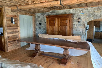 Immagine di una sala da pranzo aperta verso il soggiorno stile rurale di medie dimensioni con pavimento in legno massello medio e soffitto in legno