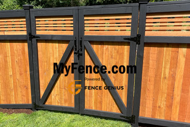 Photo of a large craftsman backyard wood fence landscaping in Seattle.