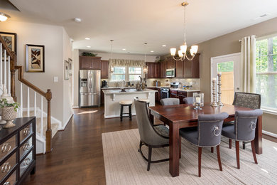 Mid-sized transitional medium tone wood floor kitchen/dining room combo photo in Raleigh with beige walls, a standard fireplace and a wood fireplace surround