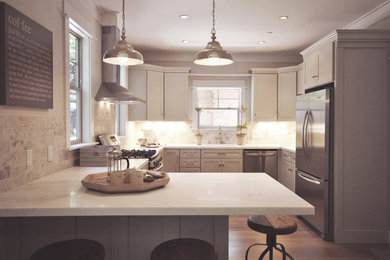 Design ideas for a mid-sized transitional u-shaped eat-in kitchen with an undermount sink, shaker cabinets, white cabinets, limestone benchtops, stainless steel appliances, medium hardwood floors, a peninsula and brown floor.