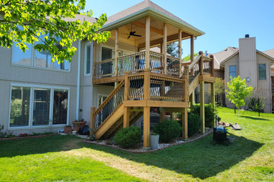 Example of a mid-sized eclectic backyard second story mixed material railing deck design in Kansas City with a roof extension