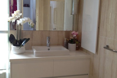 This is an example of a mid-sized modern 3/4 bathroom in Perth with a drop-in sink, white cabinets, granite benchtops, a double shower, a one-piece toilet, beige tile, ceramic tile, beige walls and ceramic floors.