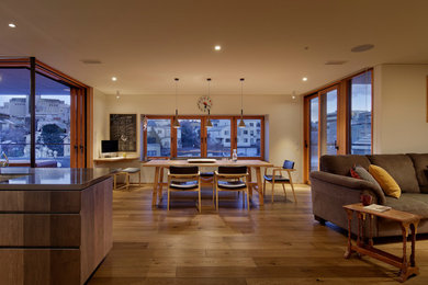 Large asian open plan dining in Tokyo with white walls, medium hardwood floors, a standard fireplace, a tile fireplace surround and brown floor.