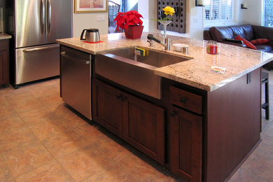 Open concept kitchen - mid-sized traditional l-shaped open concept kitchen idea in Jacksonville with a farmhouse sink, shaker cabinets, dark wood cabinets, granite countertops, stainless steel appliances and an island