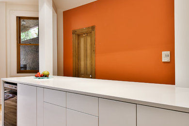 Kitchen pantry - mid-sized contemporary galley light wood floor kitchen pantry idea in Montreal with flat-panel cabinets, yellow cabinets, glass countertops, cement tile backsplash and an island
