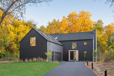 Large danish black two-story wood and board and batten exterior home photo in Minneapolis with a shingle roof and a black roof