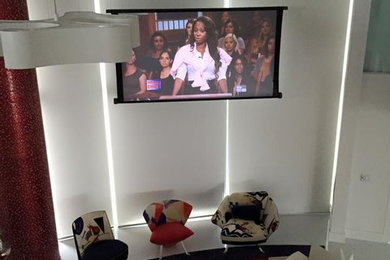 Example of a marble floor living room design in Miami with white walls and a wall-mounted tv