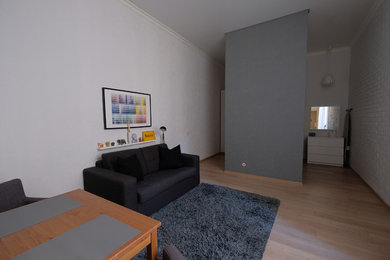 Imagen de salón abierto nórdico de tamaño medio sin televisor con paredes blancas, suelo laminado y suelo beige
