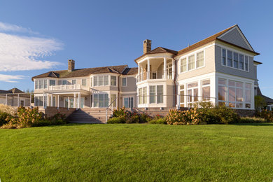 Inspiration for a huge transitional beige two-story vinyl exterior home remodel in New York with a shingle roof
