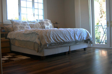 Diseño de dormitorio principal actual pequeño con paredes grises y suelo de madera oscura