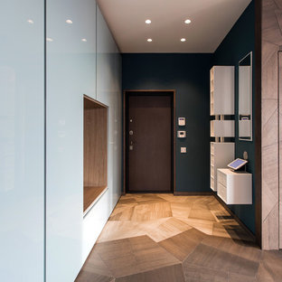 На фото: прихожие в современном стиле с одностворчатой входной дверью, коричневой входной дверью, разноцветными стенами и паркетным полом среднего тона