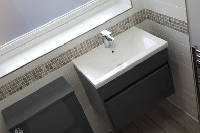 Photo of a small modern cloakroom in Surrey with flat-panel cabinets, grey cabinets, a one-piece toilet, white tiles, ceramic tiles, grey walls, porcelain flooring, an integrated sink, grey floors and a floating vanity unit.