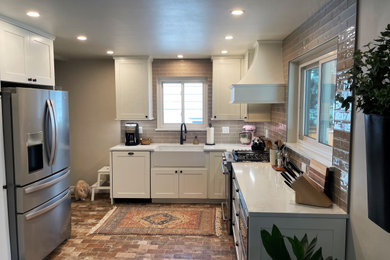 Small country kitchen in Denver with a farmhouse sink, shaker cabinets, white cabinets, quartz benchtops, beige splashback, ceramic splashback, stainless steel appliances, ceramic floors, no island, multi-coloured floor and white benchtop.