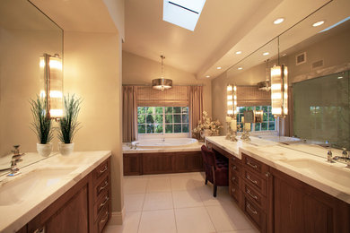 Inspiration for a large contemporary master bathroom in San Diego with an undermount sink, raised-panel cabinets, medium wood cabinets, marble benchtops, a drop-in tub, white tile, stone tile, beige walls, porcelain floors and grey floor.