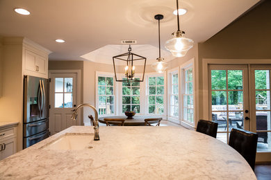 Trendy eat-in kitchen photo in Atlanta with white cabinets and an island