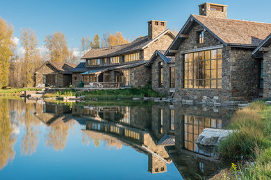 Huge mountain style brown two-story stone gable roof photo in Jackson