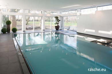 Photo of a medium sized contemporary indoor rectangular swimming pool with a pool house.