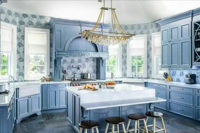 Large transitional u-shaped kitchen photo in New York with a farmhouse sink, recessed-panel cabinets, gray cabinets and an island