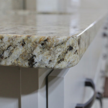 Custom white cabinetry, granite countertops, and generous storage complete this