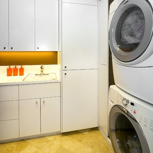 Inspiration for a modern utility room in San Francisco with a stacked washer and dryer, white cabinets and yellow floors.