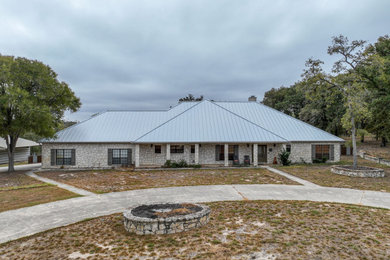Example of a one-story house exterior design in Other with a metal roof