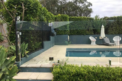 Design ideas for a mid-sized backyard rectangular pool in Newcastle - Maitland with natural stone pavers.