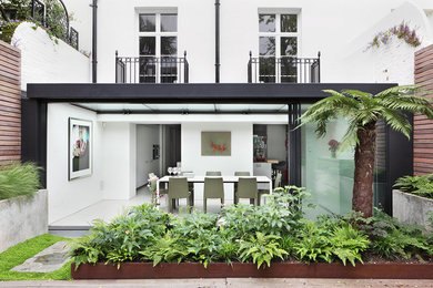 Photo of a medium sized and white modern brick terraced house in London with three floors and a tiled roof.