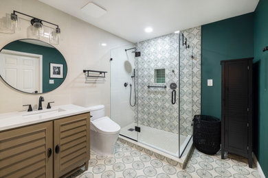 Mid-sized eclectic master beige tile and porcelain tile porcelain tile, green floor and single-sink corner shower photo in DC Metro with furniture-like cabinets, brown cabinets, a two-piece toilet, green walls, an undermount sink, quartz countertops, a hinged shower door, white countertops, a niche and a freestanding vanity