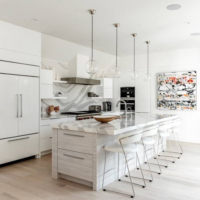 Eat-in kitchen - mid-sized contemporary galley light wood floor and beige floor eat-in kitchen idea in Boston with flat-panel cabinets, white cabinets, quartzite countertops, white backsplash, an isla