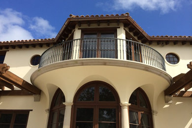 Inspiration for a mid-sized traditional two-storey stucco beige house exterior in Miami.