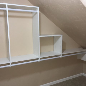 Master closet in white with sloped ceiling