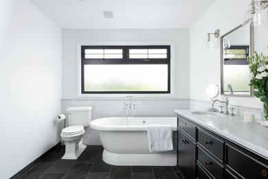Inspiration for a traditional master bathroom in Vancouver with dark wood cabinets, a freestanding tub, a two-piece toilet, white walls, an undermount sink, grey floor, grey benchtops and flat-panel cabinets.