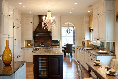 Kitchen - large traditional u-shaped laminate floor and brown floor kitchen idea in Chicago with an undermount sink, raised-panel cabinets, white cabinets, marble countertops, window backsplash, paneled appliances and an island
