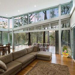 Living room of too rock home displaying louvre windows for cross ventilation - Windows