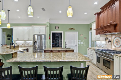 Example of a large classic single-wall ceramic tile and brown floor eat-in kitchen design in Jacksonville with an undermount sink, raised-panel cabinets, beige cabinets, granite countertops, beige backsplash, subway tile backsplash, stainless steel appliances, two islands and brown countertops