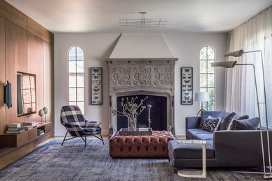 Example of a transitional family room design in Boston with white walls, a standard fireplace and a wall-mounted tv