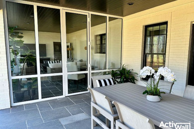 Mid-sized minimalist stone back porch idea in Other with a bbq area and a roof extension