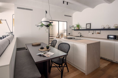 This is an example of a contemporary single-wall open plan kitchen in Barcelona with flat-panel cabinets, black splashback, panelled appliances and with island.