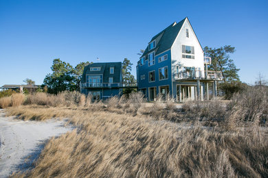 Large modern blue three-story wood gable roof idea in Other