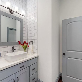 Idee per una piccola stanza da bagno con doccia minimalista con ante in stile shaker, ante grigie, piastrelle bianche, piastrelle in ceramica, pareti bianche, pavimento in laminato, lavabo a bacinella, top in quarzite, pavimento marrone e top bianco