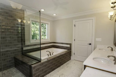 Mid-sized contemporary master bathroom in Baltimore with flat-panel cabinets, dark wood cabinets, a drop-in tub, a corner shower, a two-piece toilet, gray tile, ceramic tile, white walls, marble floors, an undermount sink, granite benchtops, grey floor, a hinged shower door and white benchtops.