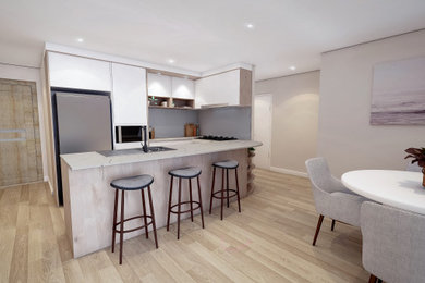 Design ideas for a small contemporary u-shaped kitchen pantry in Central Coast with white cabinets, quartz benchtops, grey splashback, glass sheet splashback, stainless steel appliances, a peninsula and grey benchtop.