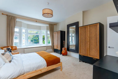 Foto de dormitorio principal bohemio grande con paredes blancas, moqueta y suelo beige