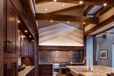 Open concept kitchen - mid-sized transitional u-shaped ceramic tile and brown floor open concept kitchen idea in Phoenix with a farmhouse sink, glass-front cabinets, dark wood cabinets, granite countertops, brown backsplash, ceramic backsplash, stainless steel appliances, a peninsula and brown countertops