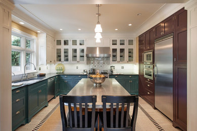 Large elegant u-shaped enclosed kitchen photo in Seattle with a double-bowl sink, glass-front cabinets, stainless steel appliances, blue cabinets, solid surface countertops, white backsplash, subway tile backsplash and an island