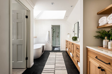 Bathroom - mid-sized country master white tile and cement tile slate floor, black floor and double-sink bathroom idea in Seattle with shaker cabinets, light wood cabinets, a one-piece toilet, white walls, quartz countertops, a hinged shower door and a freestanding vanity