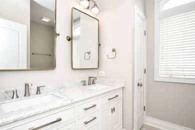 Inspiration for a medium sized classic bathroom in Chicago with shaker cabinets, white cabinets, an alcove shower, a one-piece toilet, grey walls, ceramic flooring, an integrated sink, marble worktops, grey floors, a hinged door, white worktops, a wall niche, double sinks and a built in vanity unit.