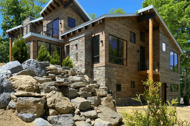Inspiration for a large rustic brown two-story wood house exterior remodel in New York